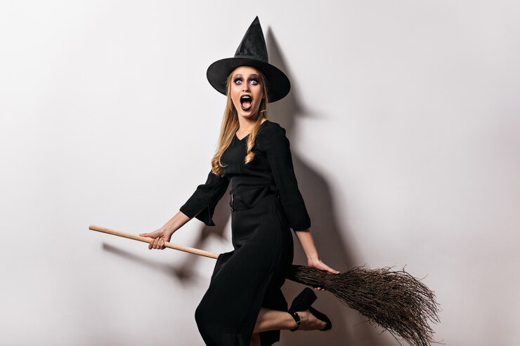 shocked-witch-with-black-makeup-posing-in-halloween-charming-blonde-lady-in-magic-hat-holding-broom_197531-15861.jpg