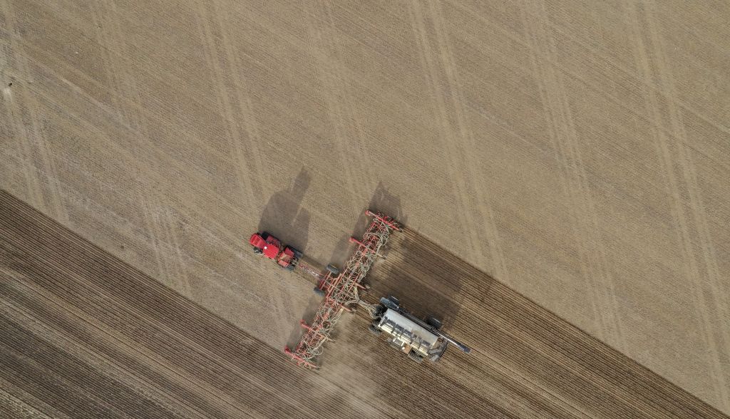 aerial-overhead-shot-of-fertilizer-machine-in-a-farming-field-during-daytime.jpg
